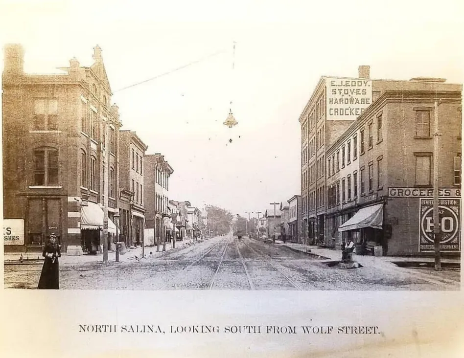 North Salina Street looking south from Wolf Street in the late 1800s, with the E.J. Eddy Stoves, Hardware and Crockery sign painted high on the five-story brick building